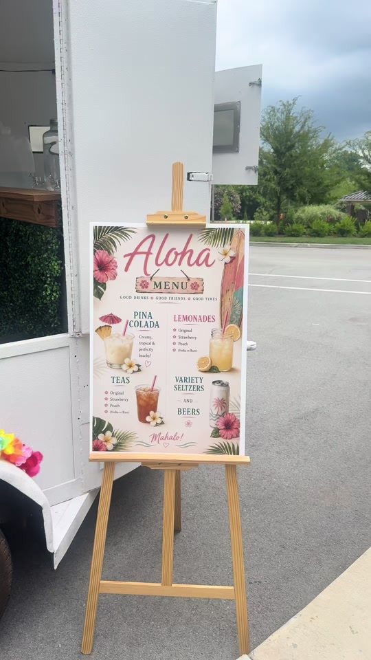 A printed Aloha menu on an easel listing piña colada, lemonades, teas and seltzers