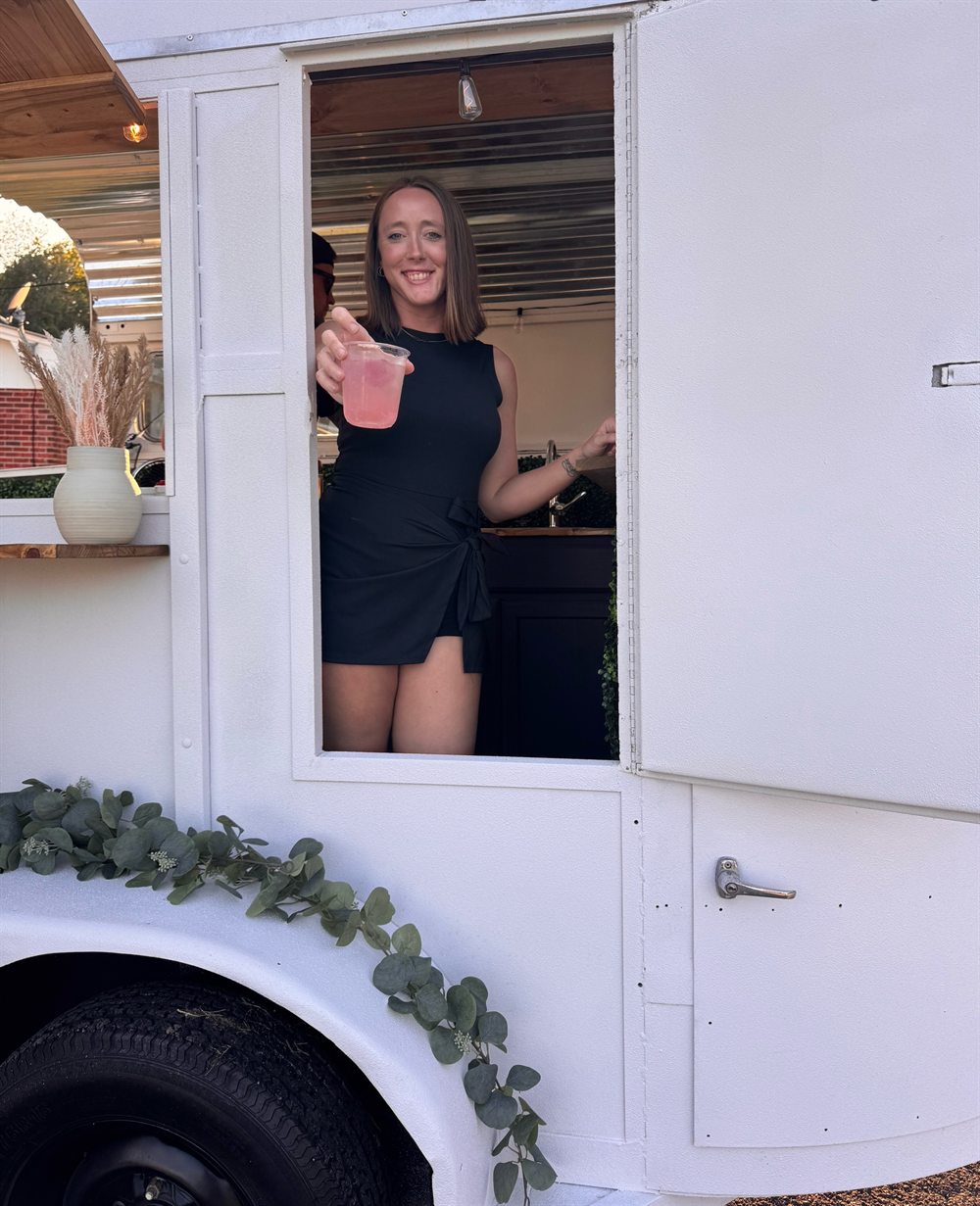 Handing a fresh pink lemonade out of the trailer window